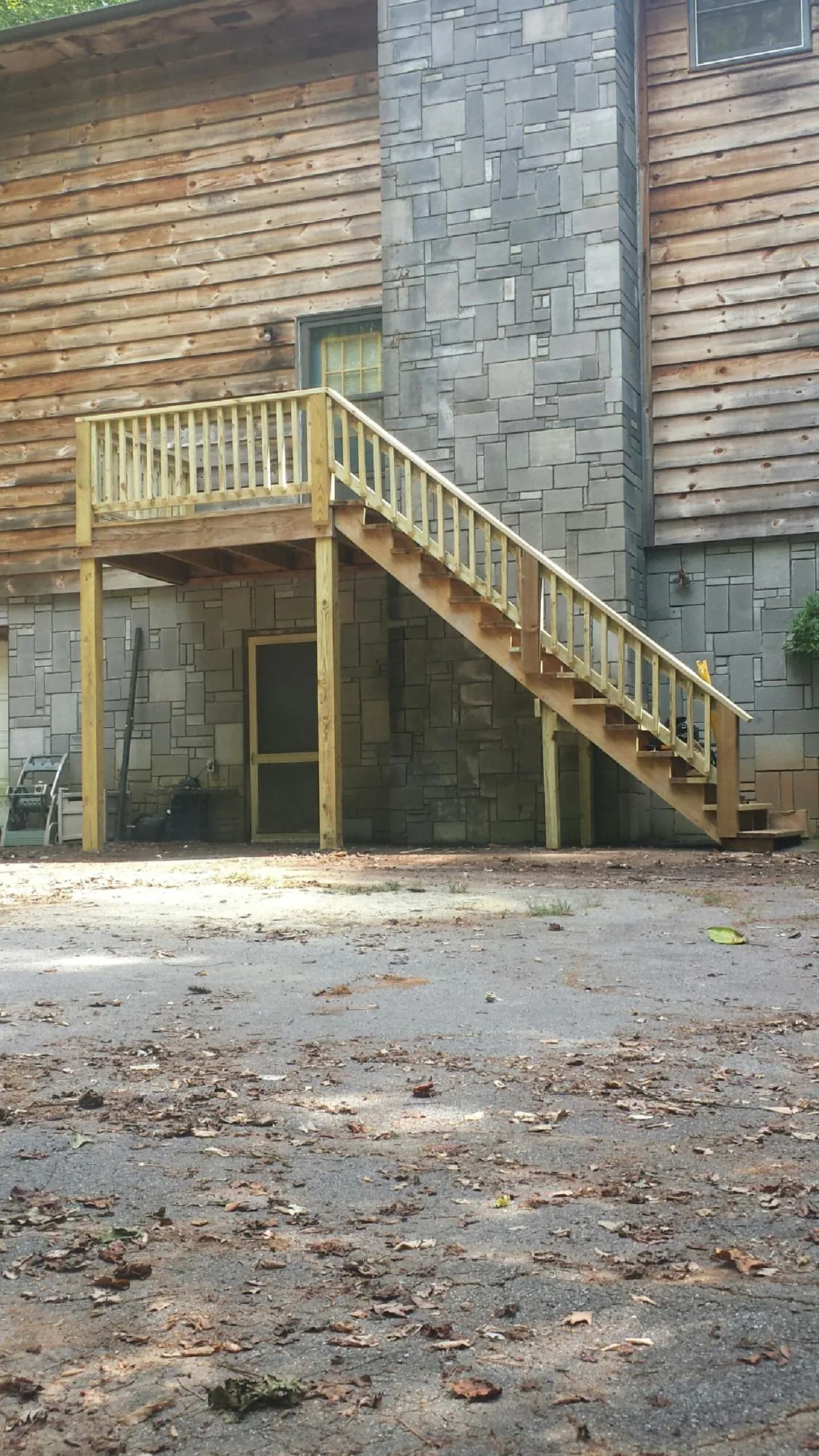New pressure treated deck and stair landing on a log home in Baxter